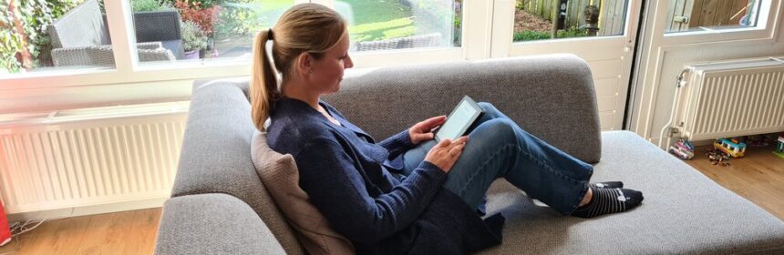 Een vrouw met een kobo ereader op de bank